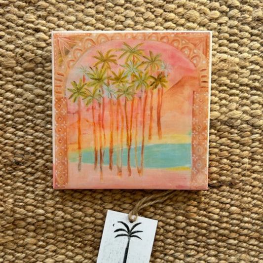 Artistic depiction of palm trees and a sun on a decorative tile.