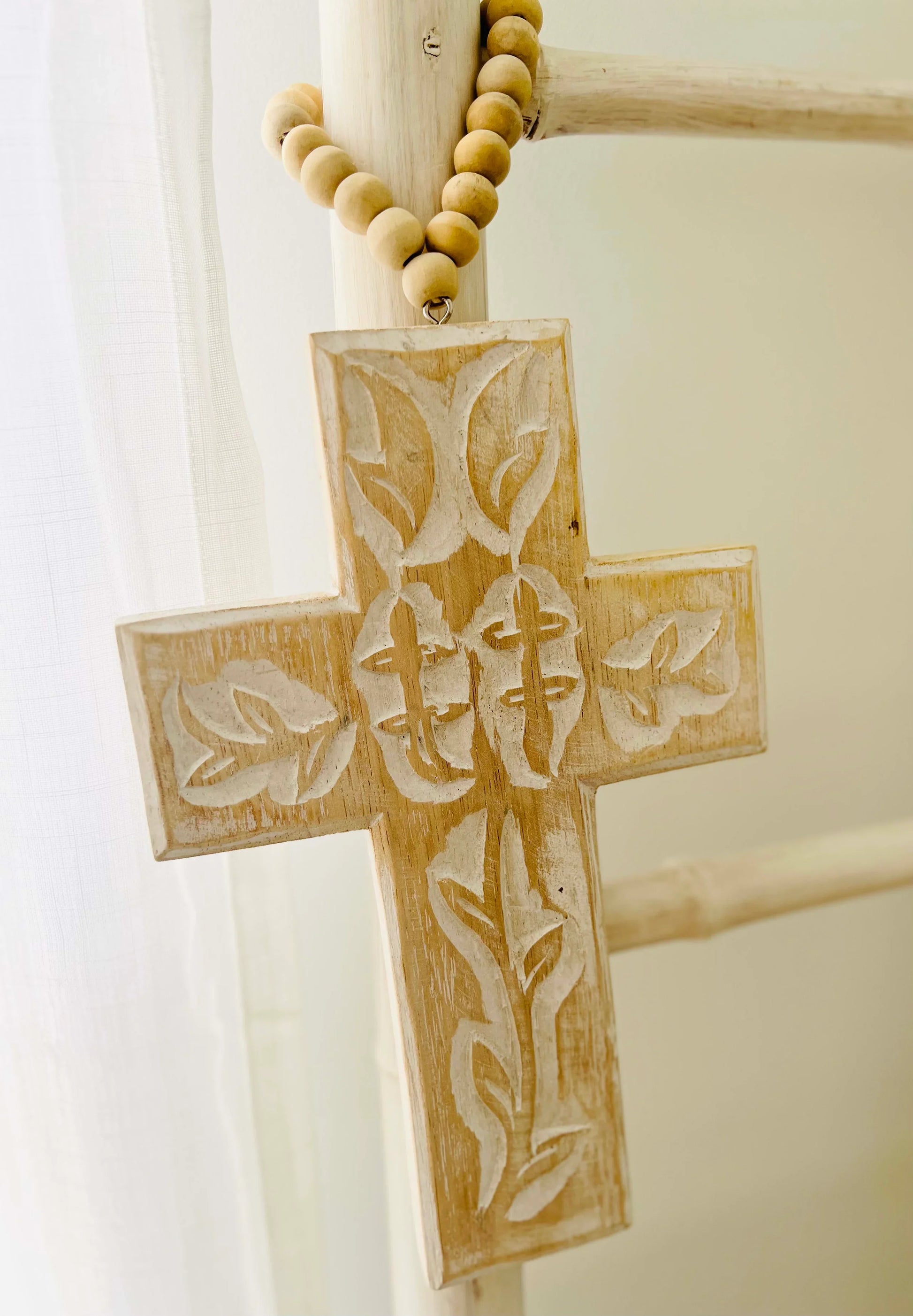 Wooden cross with engraved design on a white background