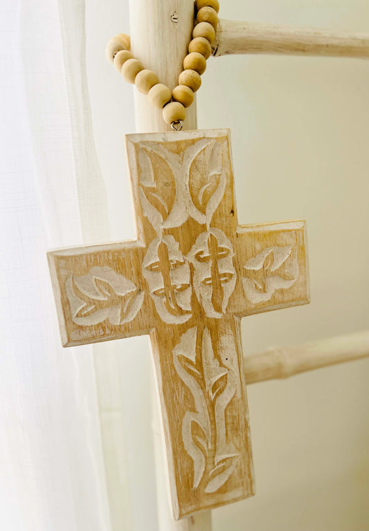 Wooden cross with engraved design on a white background