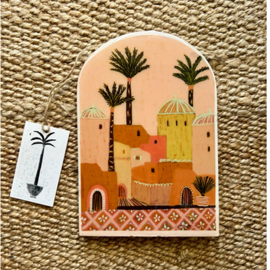 Decorative wall hanging with a desert scene design on a textured surface