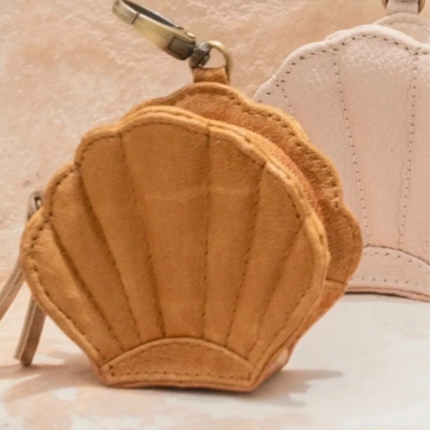Brown shell-shaped keychain on purse on a light background