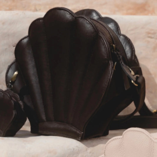 Brown leather shell-shaped handbag on a beige surface