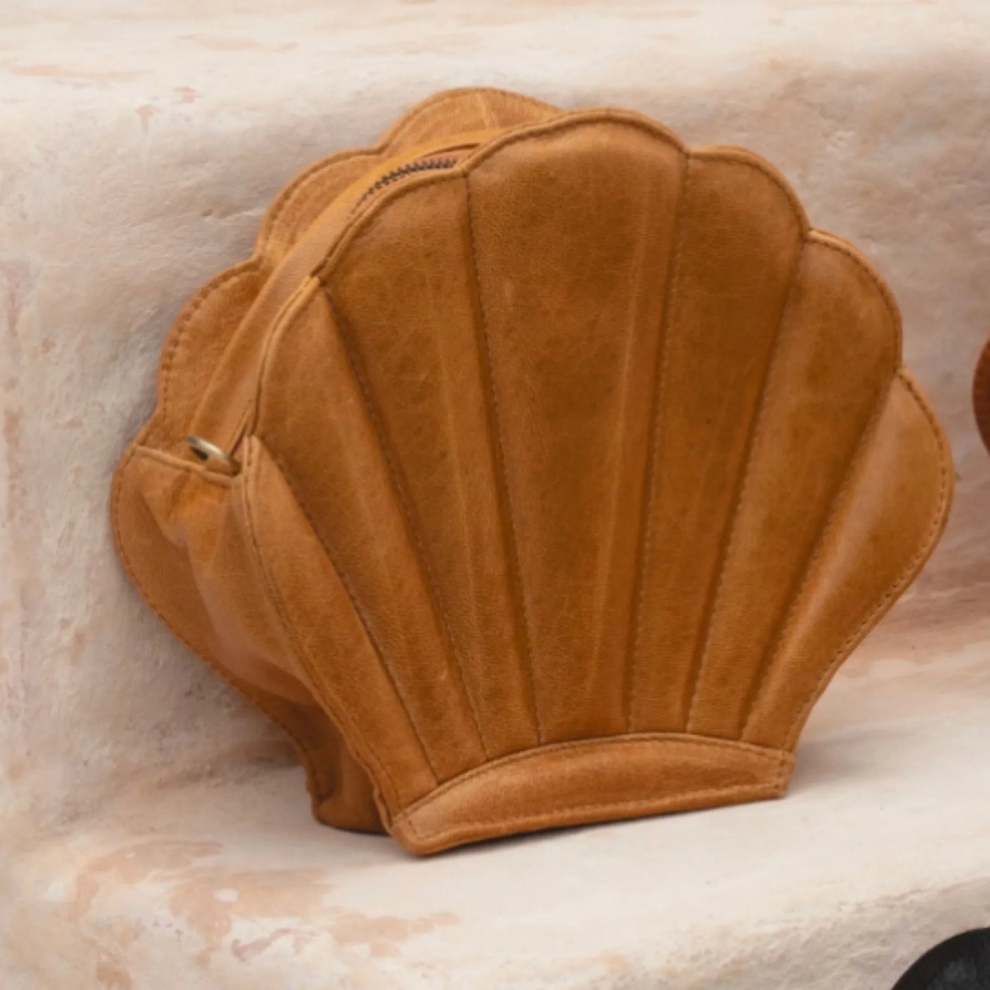 Brown shell-shaped handbag on a marble surface