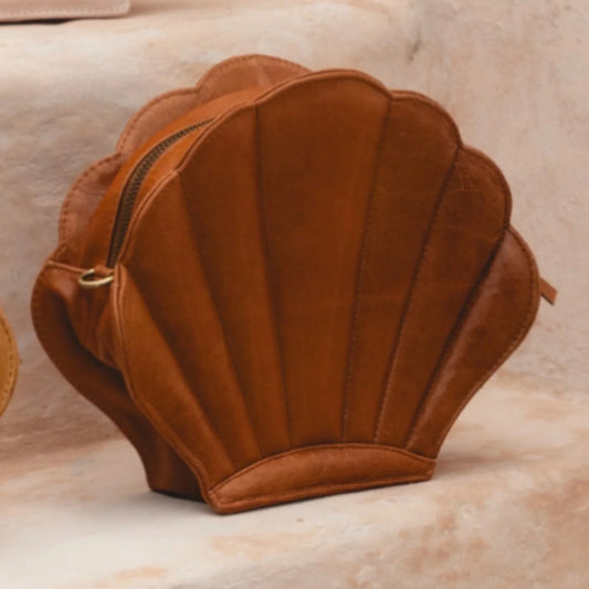 Brown shell-shaped bag on a beige surface