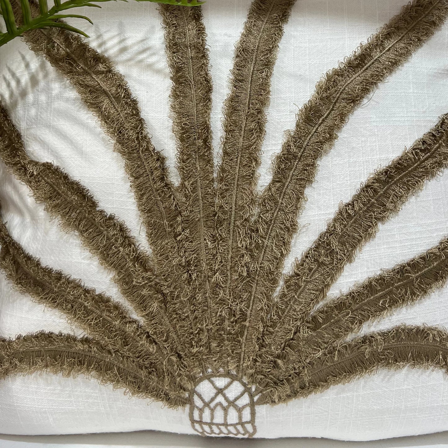 Cushion with textured brown leaf design on a white background