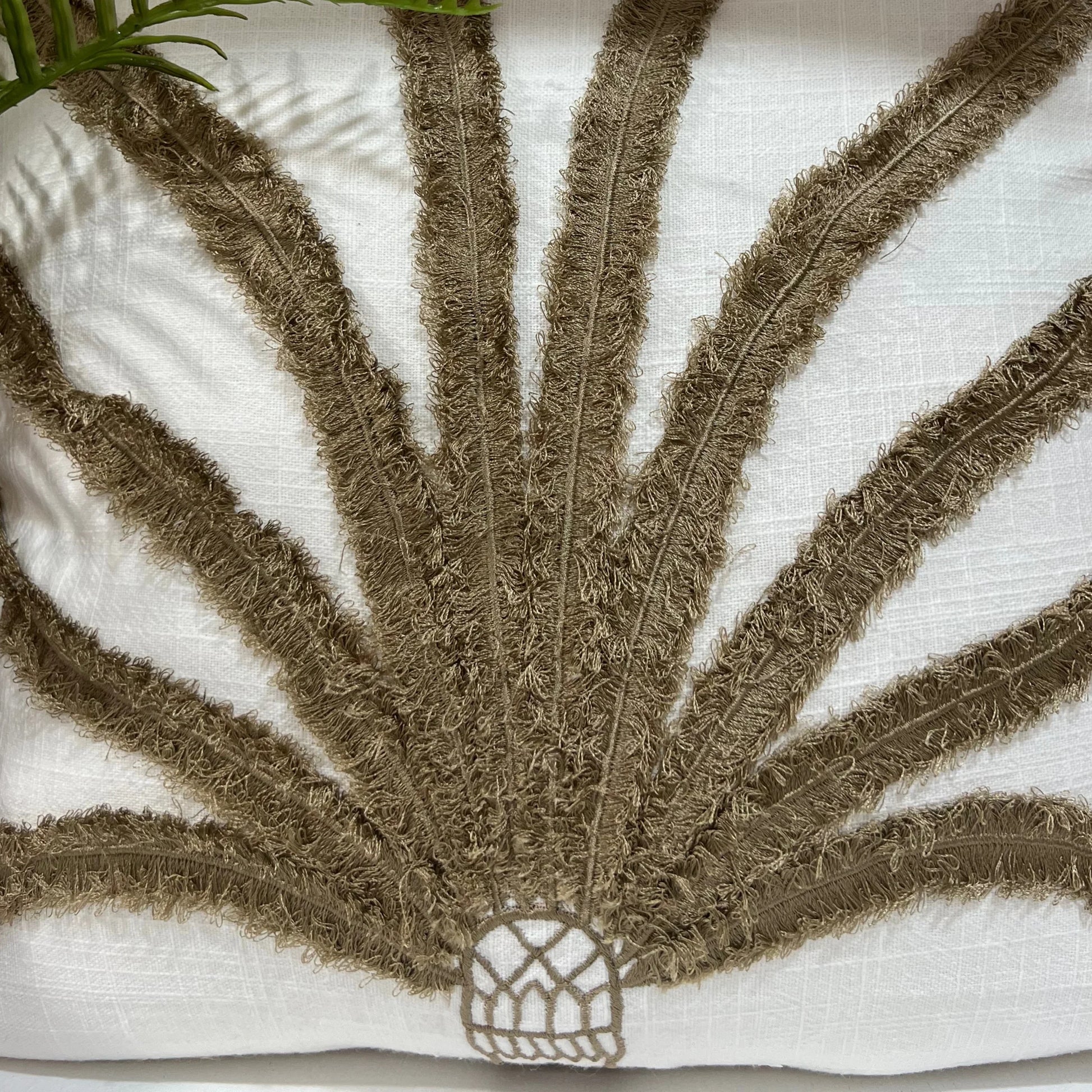 Cushion with textured brown leaf design on a white background