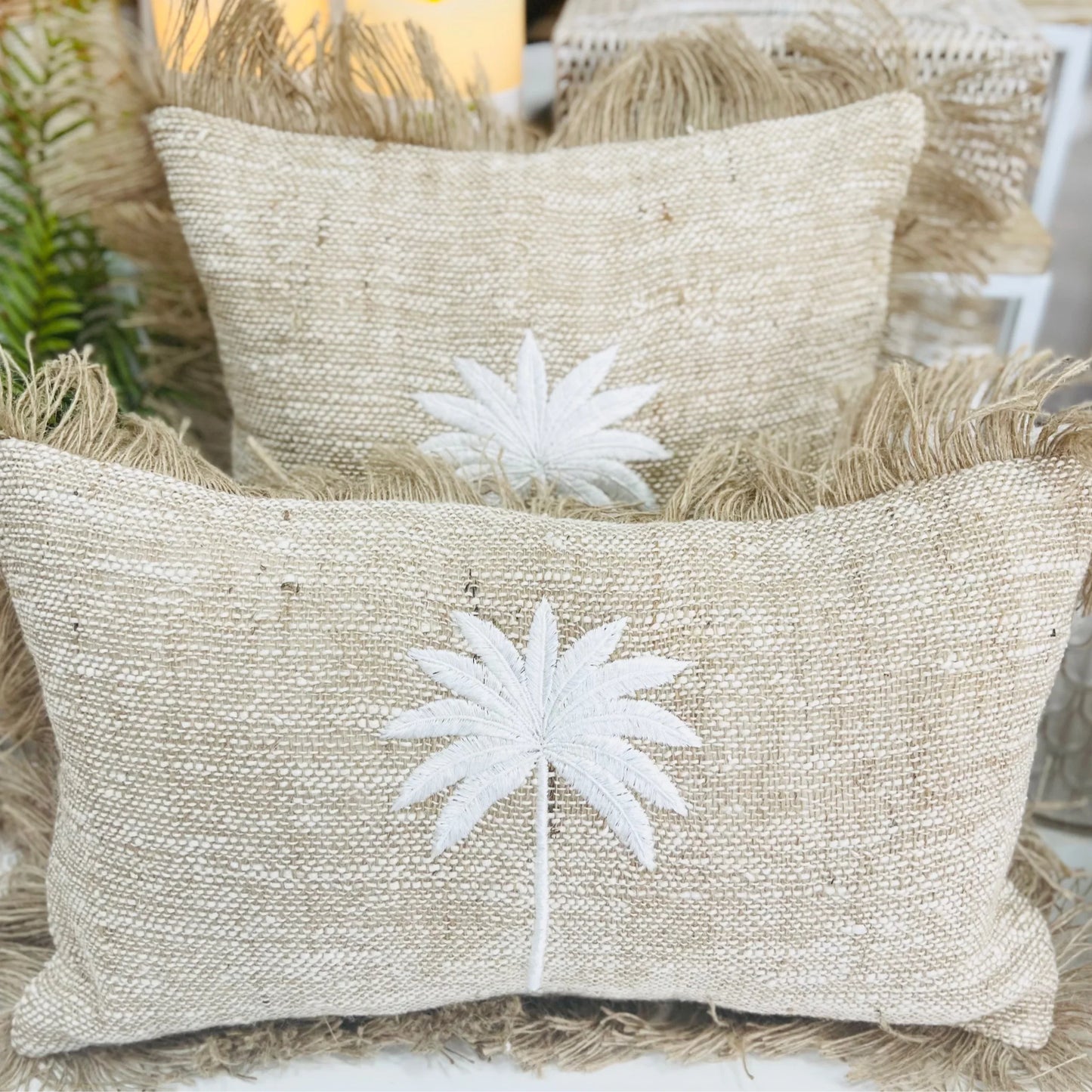 Beige pillows with white embroidered palm tree design