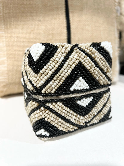 Beaded trinket box with black and white pattern on a neutral background