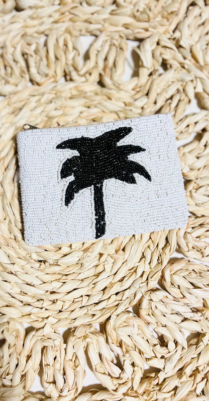 Small coin purse with a palm tree design on a woven surface