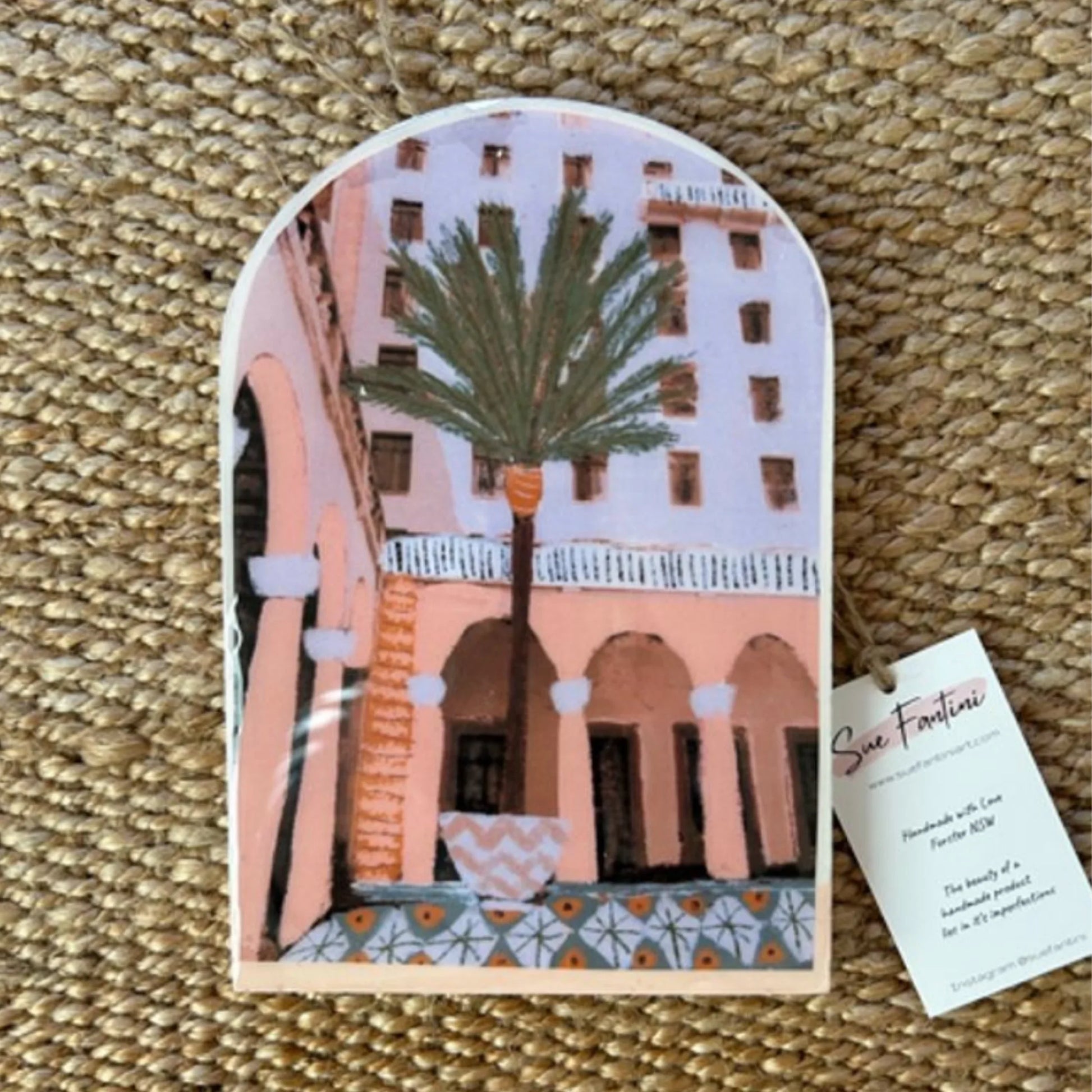 Decorative tile with architectural design and palm tree on a textured surface
