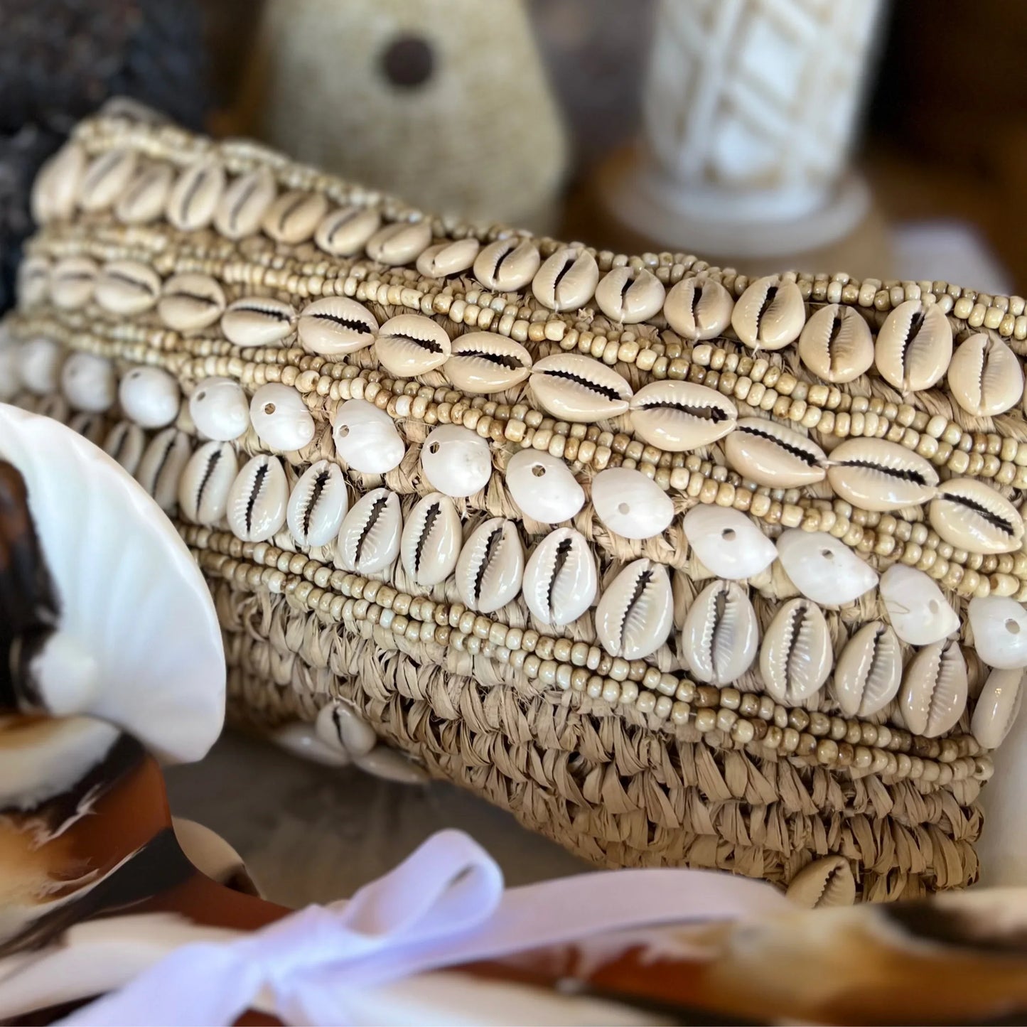 Clutch bag with shell and bead embellishments on a textured surface