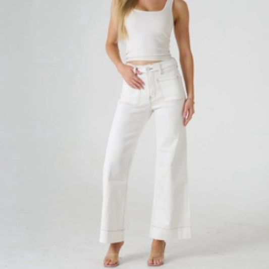 Person wearing a white tank top and wide-leg pants on a plain background