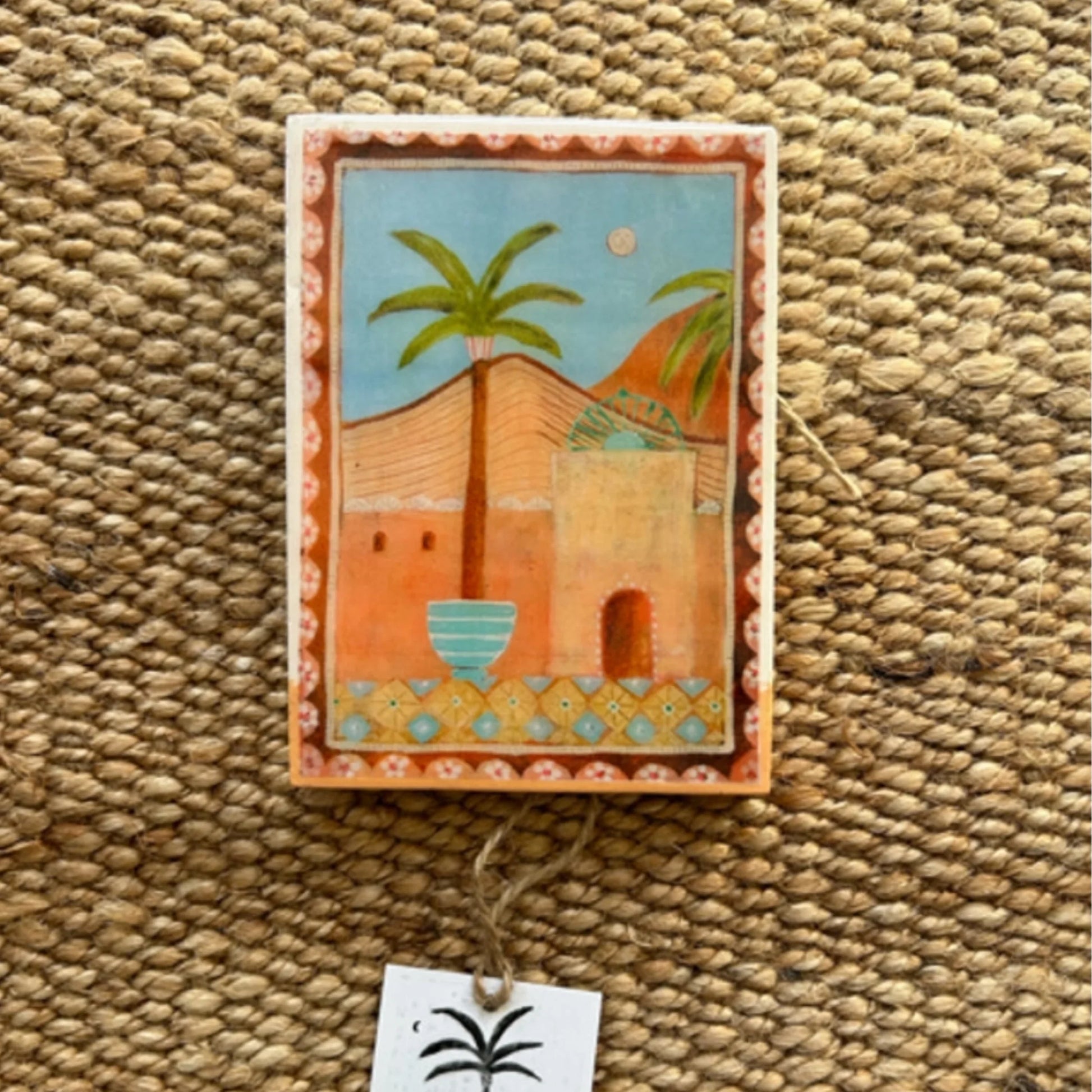 Decorative wall hanging with a palm tree design on a textured surface