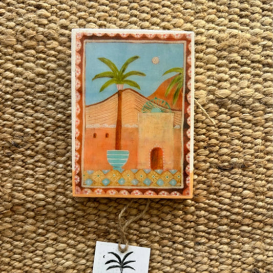 Decorative wall hanging with a palm tree design on a textured surface