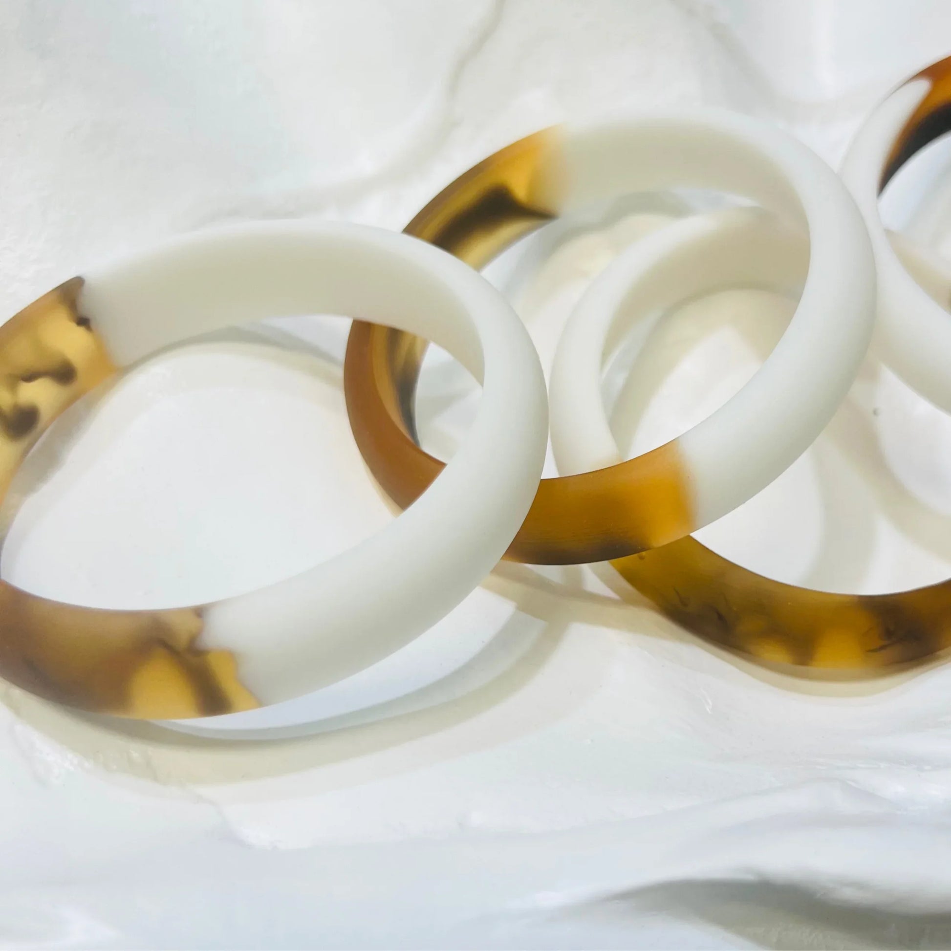 Two resin bangles on a white sheet