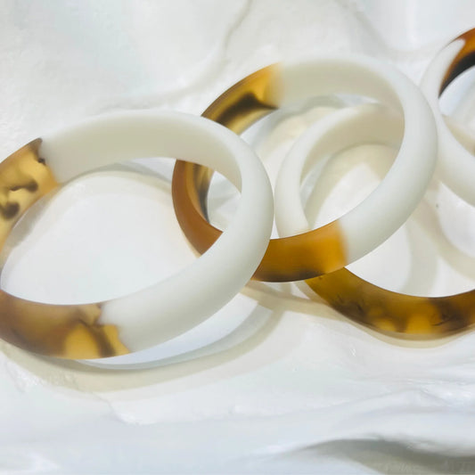 Two resin bangles on a white sheet