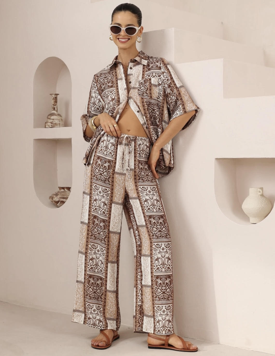 Woman wearing a patterned outfit in a minimalistic room.