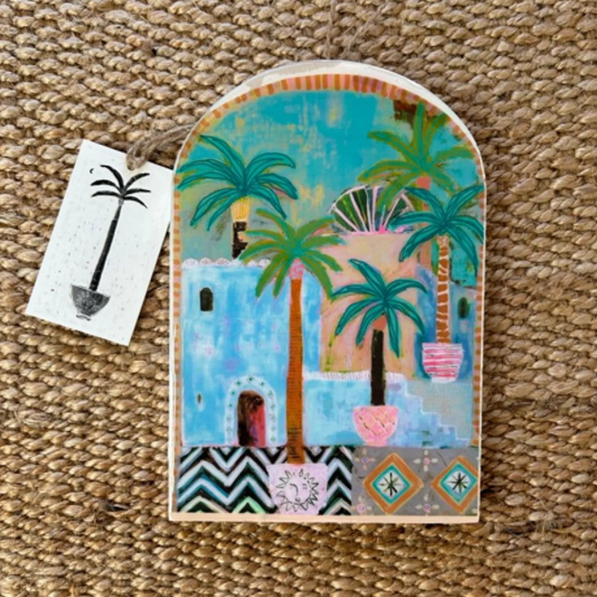 Decorative wall art with palm trees and arch design on a textured surface