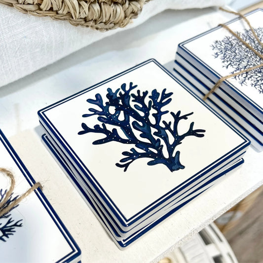 Set of ceramic coasters with blue coral design on a white surface
