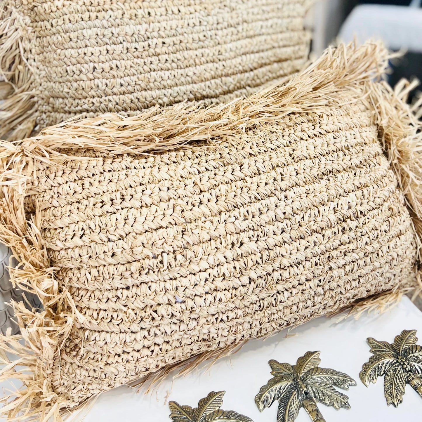 Close-up of straw cushions with palm tree design on a white surface